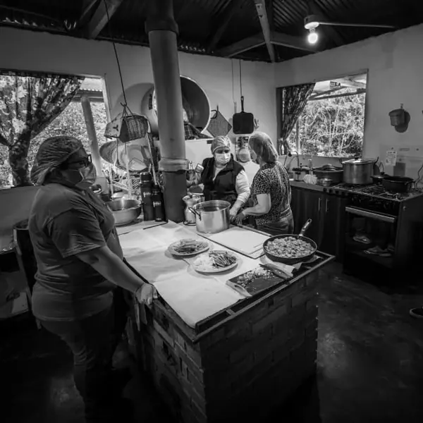 Cocina de campo en blanco y negro con personas preparando comida